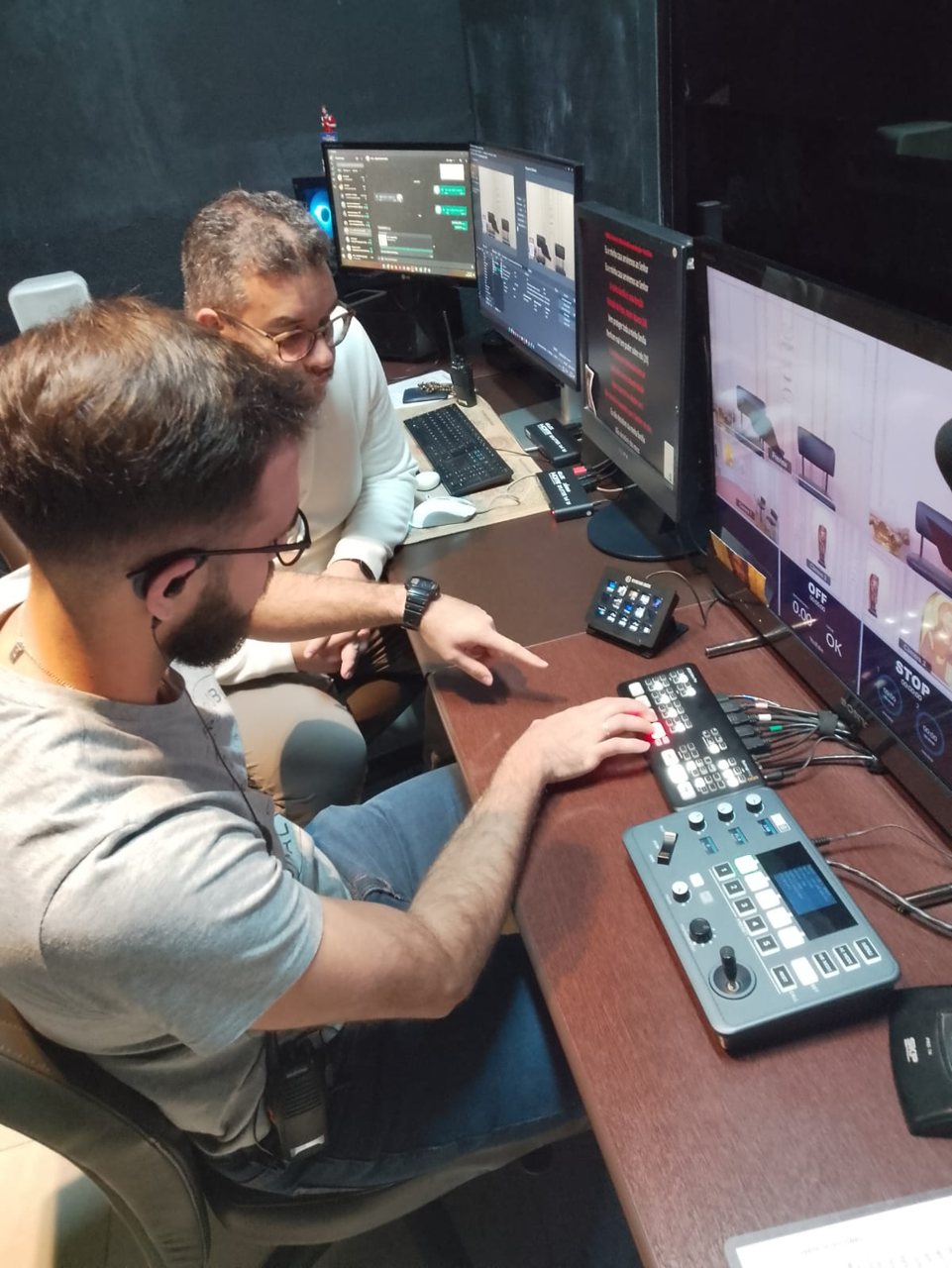Registro da equipe observando a operação de uma mesa de corte em estúdio audiovisual